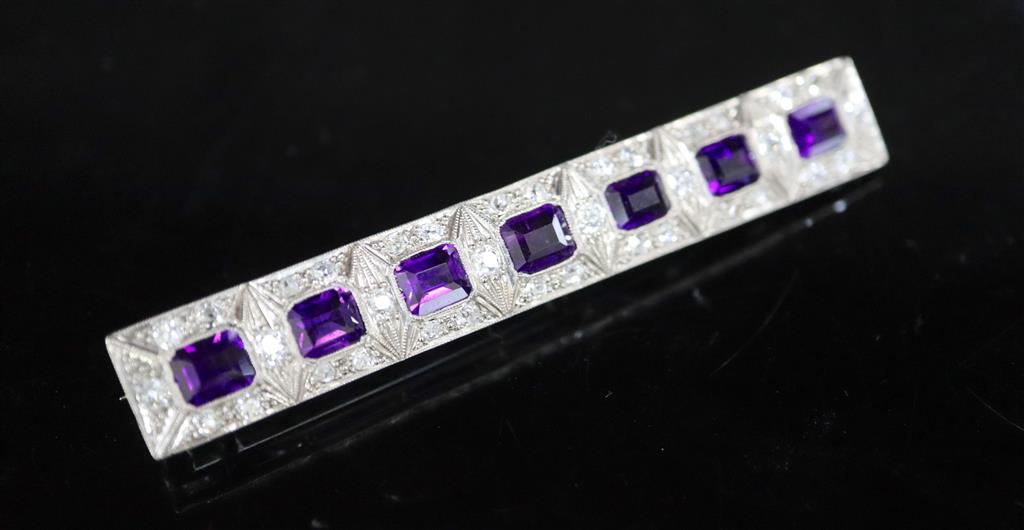 An early to mid 20th century 18ct white gold, amethyst and diamond cluster set bar brooch,